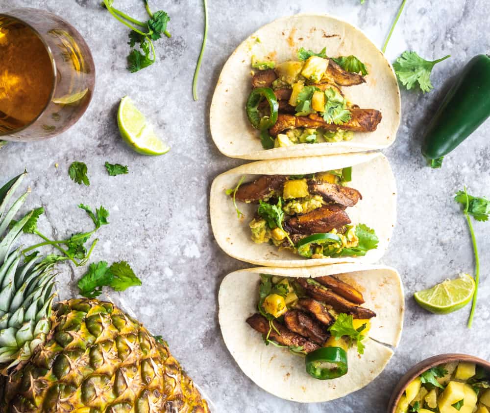 Marinated vegan asada mushroom tacos with pineapple salsa, avocado, jalapenos, and cilantro