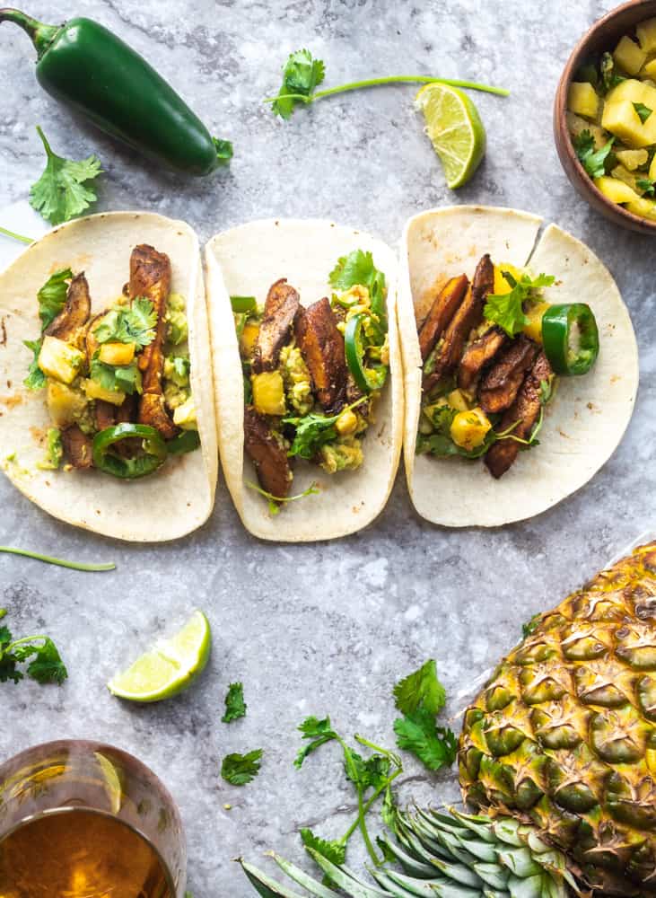 Marinated vegan asada mushroom tacos with pineapple salsa, avocado, jalapenos, and cilantro