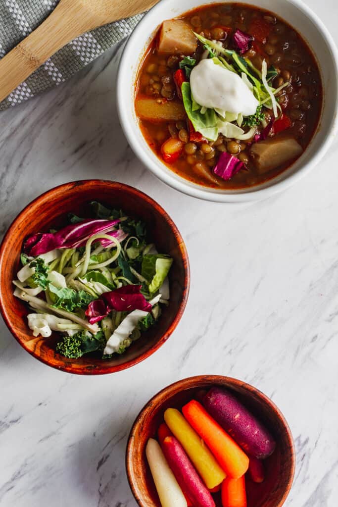 vegan green lentil soup with carrots, potatoes, and kale