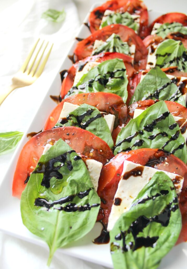 tofu, lettuce, tomatoes, and balsamic vinegar on white tray