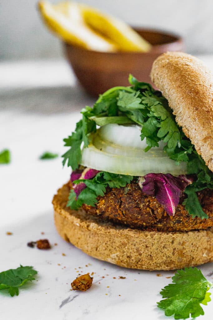tempeh chorizo spiced vegan torta with cilantro, purple lettuce, onions, buns, and roasted potatoes