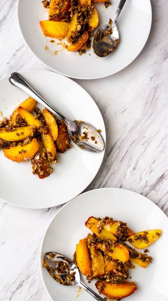 peach crisp on white plates with spoons